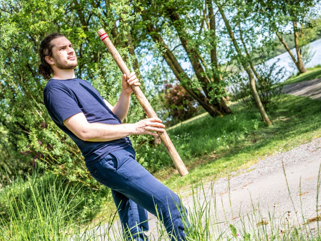 Homme qui joue du bâton de pluie