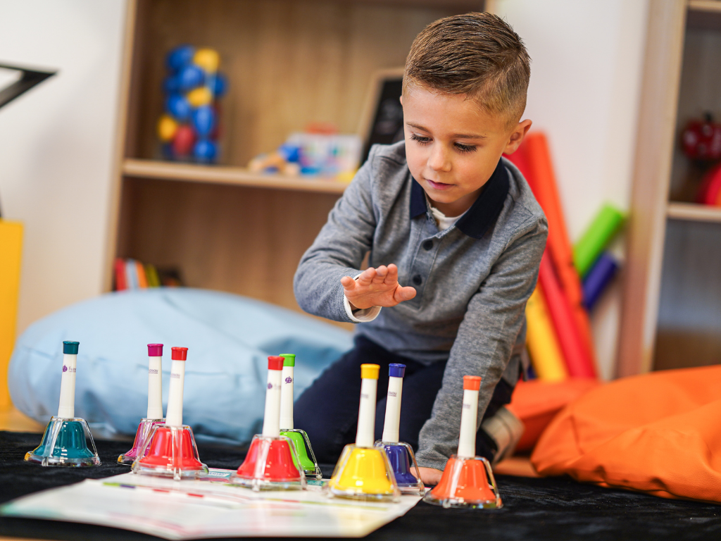 Enfant qui joue des cloches colorées