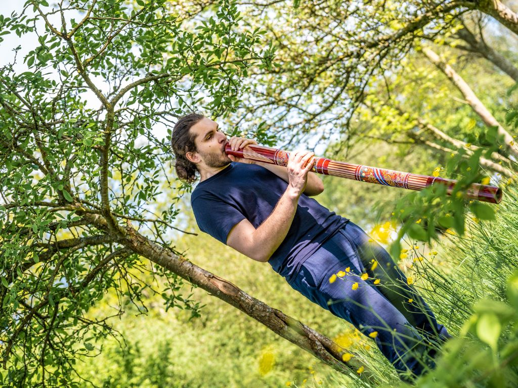 Homme qui joue du didjeridoo dans la nature