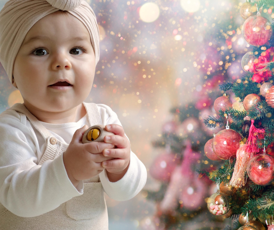 Petite fille avec hochet sur fond Noël